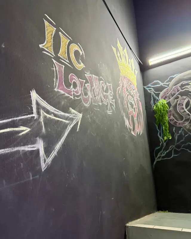 “IIC Lounge” drawn in chalk on a dark wall, next to an arrow.