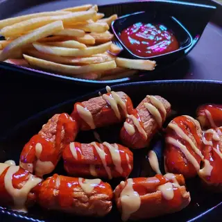 Kentang goreng bersama sos, dan sosej disiram dua jenis sos.
