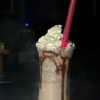 Milkshake dengan krim putar dan sos coklat.