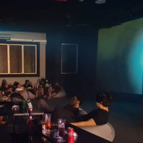 Movie night: guests on bean bags in front of the big screen.